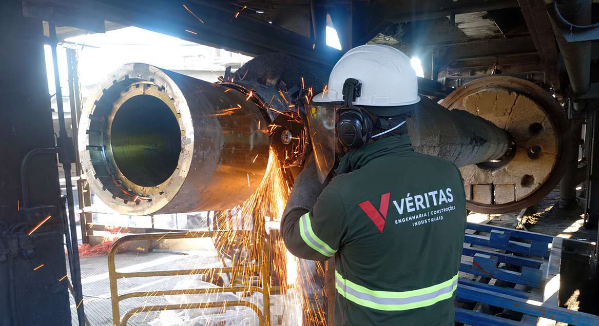 Profissional com uniforme Véritas em intervenção de manutenção industrial